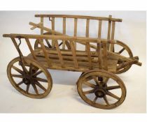 Vintage wooden dog cart fitted with four eight-spoke wooden wheels with metal mounts and T-bar