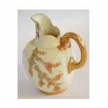 Royal Worcester globular jug with gilt handle the blush body decorated with flowers, 17cm high