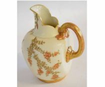 Royal Worcester globular jug with gilt handle the blush body decorated with flowers, 17cm high