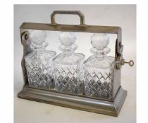 Chromium framed tantalus fitted with four square decanters with faceted stoppers and cut bodies,