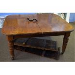 Edwardian oak extending dining table on four ring turned legs, raised on porcelain casters (with