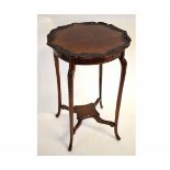 Edwardian mahogany circular carved top occasional table on four shaped legs, supported by an X