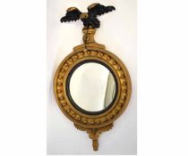 19th century gilt convex circular wall mirror with eagle mounted top, with carved base, 84cms