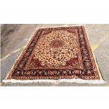 Modern Keshan carpet with cream ground with central red floral lozenge with foliage surround with