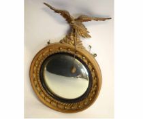 19th century gilt framed convex wall mirror with carved eagle top, 60cms