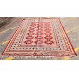 Modern Bokhara type carpet with cream and red field, with repeating lozenge centre with multi-gulled