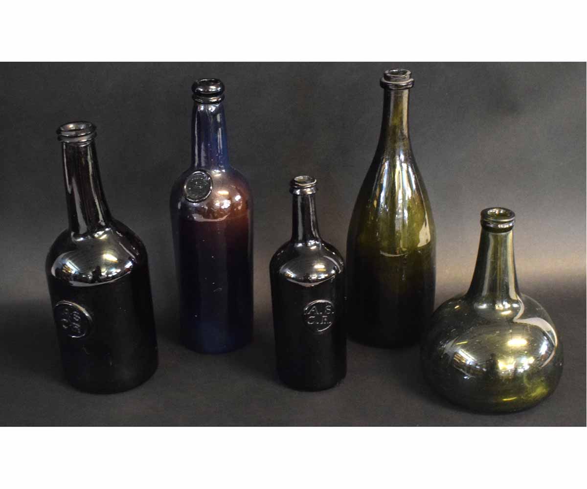 Group of five antique bottles with various impressed letters including ASCR and one bottle impressed