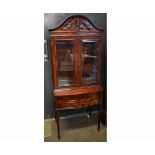 Good quality mahogany display cabinet on stand fitted with two glazed doors with arched and carved