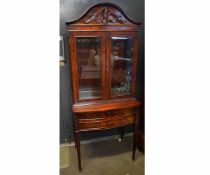 Good quality mahogany display cabinet on stand fitted with two glazed doors with arched and carved