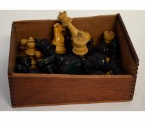 Box containing assorted carved and stained chess pieces