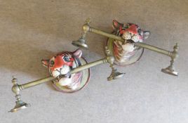 Group of four interesting early 20th century tiger mask wall lights ceramic head with brass poles to