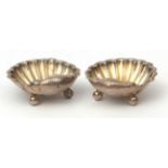 Two late Victorian shell salts each of typical form and raised on three ball feet, width 5.2cms,