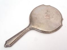 Early 20th century silver backed dressing table hand mirror, of shaped circular form with engine