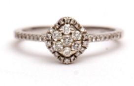 Precious metal engagement ring, modern diamond halo cluster design, the centre having seven small