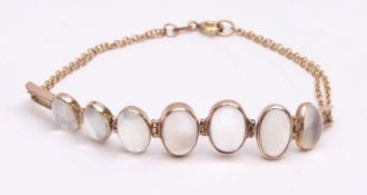 Moonstone bracelet having seven oval shaped cabochon moonstones, each in a collet setting, the clasp