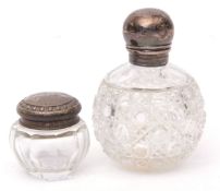 Mixed Lot: two various silver lidded and clear cut glass toiletry bottles, first of spherical form