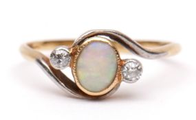 Precious metal opal and diamond cross-over ring, the central bezel set opal flanked by two small