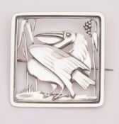 Arts & Crafts white metal brooch, a square open work design depicting a pelican amongst reeds, 40