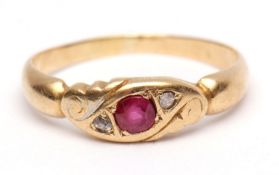 Yellow metal ruby and diamond ring, the central faceted ruby set between two small rose cut