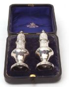 Cased pair of late Victorian pepper casters, each of baluster form with pierced pull off covers on