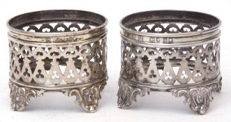 Two Victorian bottle stands, each of pierced circular form and raised on four cast and applied feet,