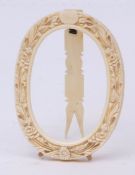 19th century carved ivory oval photograph frame with floral surround and easel back (incomplete),