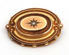 Antique yellow metal mourning brooch, oval shaped design, having a small diamond set centre in a