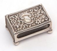 Edward VII matchbox holder of typical rectangular form with embossed cover and raised on four ball