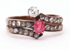 Precious metal diamond crossover ring, set with an old cut diamond and small ruby (a/f), both raised