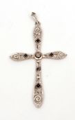 Precious metal cross pendant, having a central bezel set diamond, the pierced scrolled design set