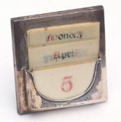 George V silver mounted easel backed desk calendar of square form with ivorine inserts for days of