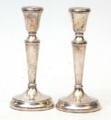 Two Elizabeth II single candlesticks, each with fixed sconces on tapering columns and spreading