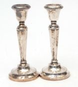 Two George V single candlesticks, each with fixed sconces on tapering and faceted columns on