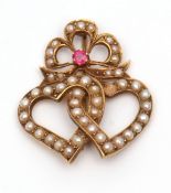 Yellow metal seed pearl and ruby heart brooch, a design of two seed pearl entwined open work