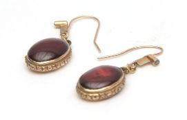 Antique pair of yellow metal, garnet and diamond set earrings, having oval shaped cabochon garnets