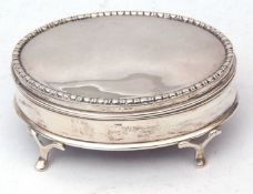 George V dressing table casket of polished oval form with hinged cover, velvet lined interior on