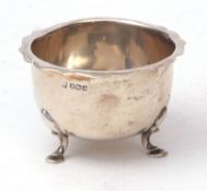 George V small bowl of polished form with cut card rim and raised on three cast feet, width 8 1/2