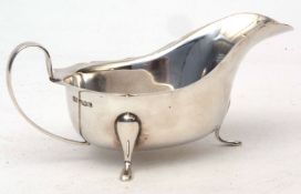 George VI gravy boat with cut card rim, applied strap handle and raised on applied feet, length