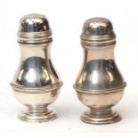 Two George V pepper casters, each of girdled baluster form with pierced and pull off covers on