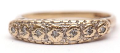 9ct gold small diamond ring, the seven small bezel set diamonds in an engraved and pierced gallery