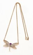 Modern yellow metal amethyst and diamond dragonfly pendant, the head set with a heart shaped