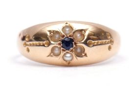 Late Victorian 15ct gold sapphire and seed pearl ring, the small central set sapphire surrounded