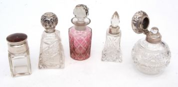 Mixed Lot: three various silver lidded and clear cut glass toiletry bottles together with a fourth
