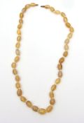 Vintage citrine coloured glass bead necklace, a single row of graduated oval shaped beads to a