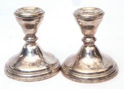 Two Elizabeth II squat candlesticks, each with fixed sconces on spreading circular bases (loaded),