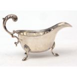 George V sauce boat with cast and applied border, leaf capped handle on three feet, width 14cms,