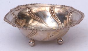 Edward VII bowl of shaped oval form with embossed rim and field raised on four ball feet, width 14.