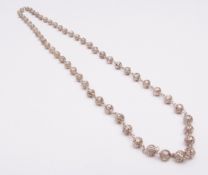 Modern white metal necklace, consisting of various pierced spheres joined by chain connectors,