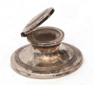 George V capstan inkwell of typical form with hinged cover containing a clear glass liner (