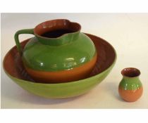 Large washing bowl and jug and a smaller vase, the pottery bodies decorated in buff and green glaze,